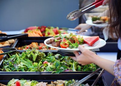 a close up of salads and food being served onto a plate